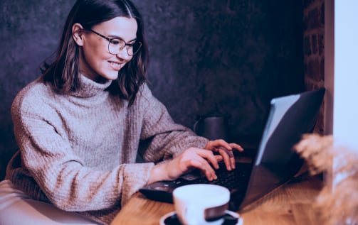 Jeune femme travaillant sur son ordinateur portable dans un café